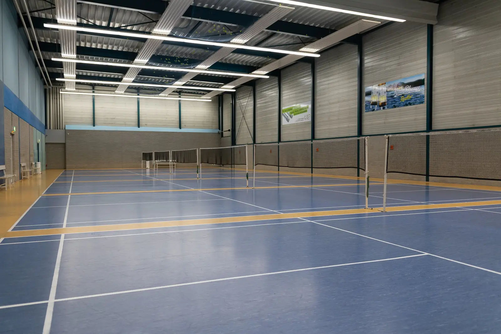 Badmintonhalle mit blauem Boden und Netzen
